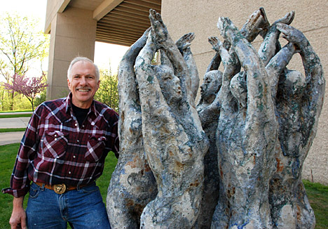 Mark Chatterley posed for a photo by his sculpture, “Fairy Circle,” after installing it on Health Science Campus.