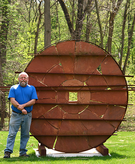 Tom Lingeman posed for a photo with one of his works titled “New World.”