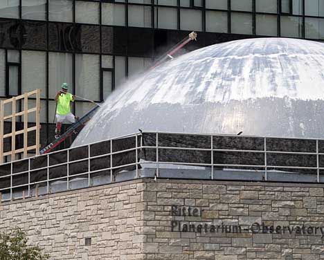 A worker from Lakeside Interior Contractors Inc., Perrysburg, power-washed the paint off Ritter Planetarium’s dome earlier this month. The structure has been repainted as part of the renovation.