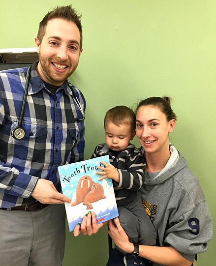 UT Pediatric Resident Dr. Joseph Giancarlo participated in Reach Out and Read by providing a new book to Rocket Pediatrics patient Jasper Vaez and his mother, Abigail.