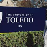 Tim Cullaz stands next to the UToledo sign on Main Campus. He is the first student to receive a dual-institution Ph.D. in mechanical engineering between UToledo and École Nationale d'Ingénieurs de Brest in France.
