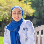 Dema Herzallah, who graduates Saturday with her bachelor of science degree in nursing, smiles for a photo outside in her UToledo nursing jacket.