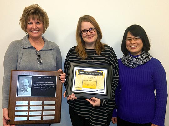 Phoebe Ballard, director of instructional design and development, center, showed off the Mark A. Yeary Award she was presented by Dr. Barbara Kopp Miller, associate provost for online education, who held the plaque where Ballard’s name was added, and Dr. Mingli Xiao, senior instructional designer.