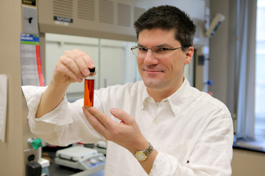 Dr. Terry Bigioni, professor in the Department of Chemistry and Biochemistry, held a vial of silver nanoparticles in liquid form.