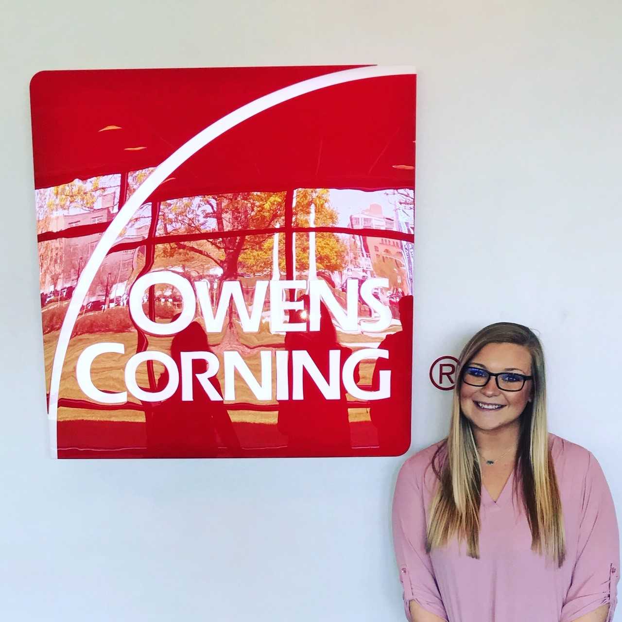 Carley Palmer in front of Owens Corning sign
