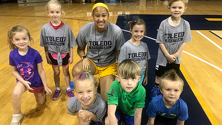 Mariah Copeland poses with children in Coach Cullop's Kids Camp