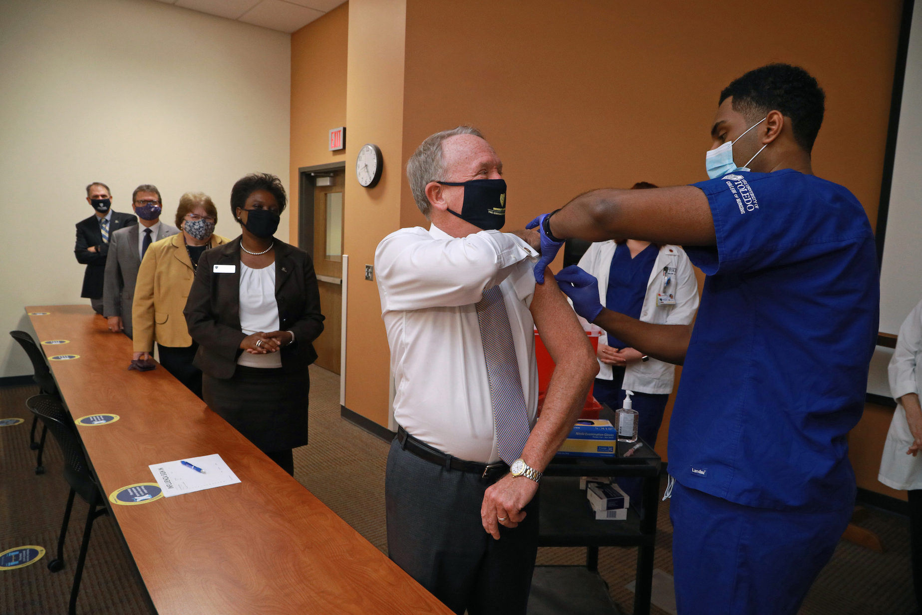 Interim President Gregory Postel receives his flu shot from nursing student
