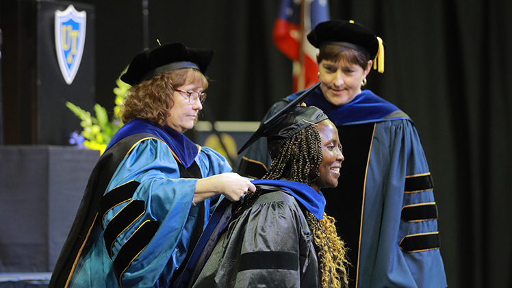 Ph.D. Candidate Roseline Nyaboke is hooded during Commencement