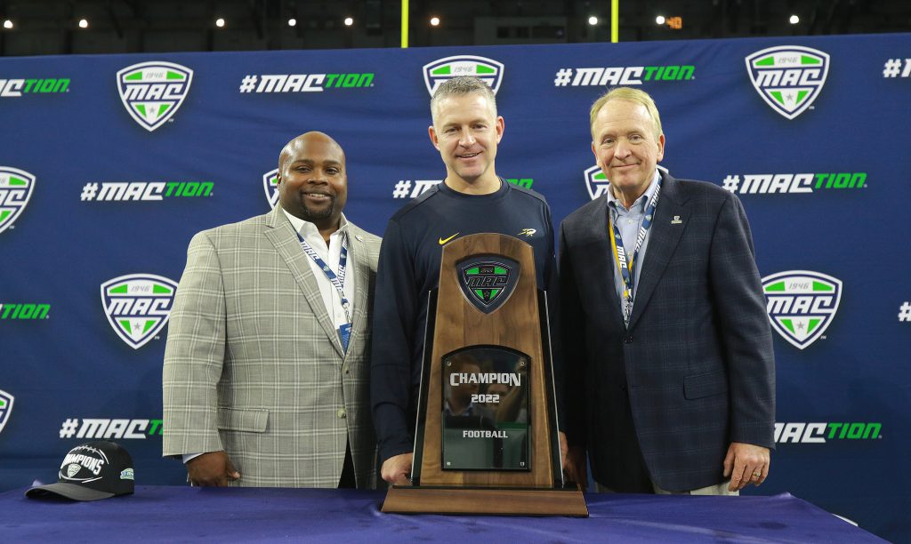 AD Bryan Blair, Coach Jason Candle and President Gregory Postel pose with MAC Championship Trophy