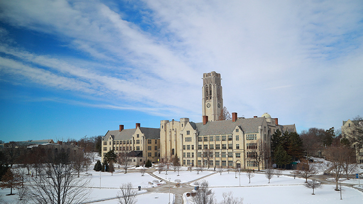 Back of University Hall from Snyder Memorial with snow on the ground and a bright blue sky