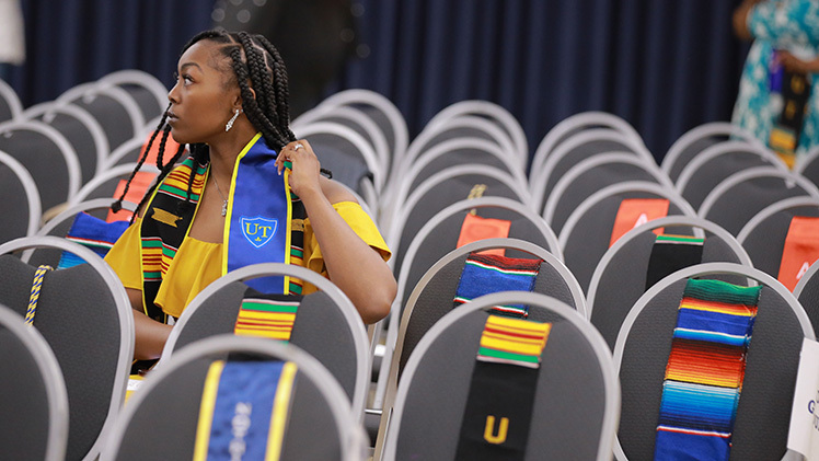 Kiyana Rome, who is graduating with a degree in business management, adjusts her stole before the beginning of Thursday evening’s Multicultural Graduation ceremony in Thompson Student Union Auditorium.