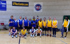 Players on two teams in the Unified Intramural League stand together for a photo on a basketball court