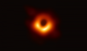 First image of a black hole in outer space. A ring of orange on a black background.