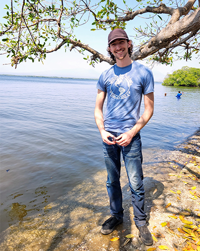 Photo of UToledo student Dalton Mitchey on the bank of a lake.