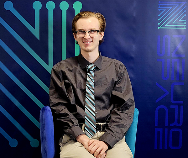 Photo of UToledo engineering graduate Nash Benton posing for a photo in a chair at his engineering and business development internship with Neurospace GmbH in Berlin. 