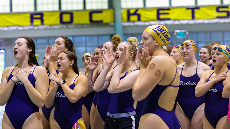 The Toledo Women's Swimming Team react during a match.