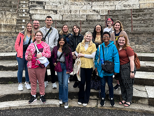 Jordyn Fearon, left, and other UToledo students and faculty and staff pose for a photo in ancient ruins during their trip to Sorrento, Italy.