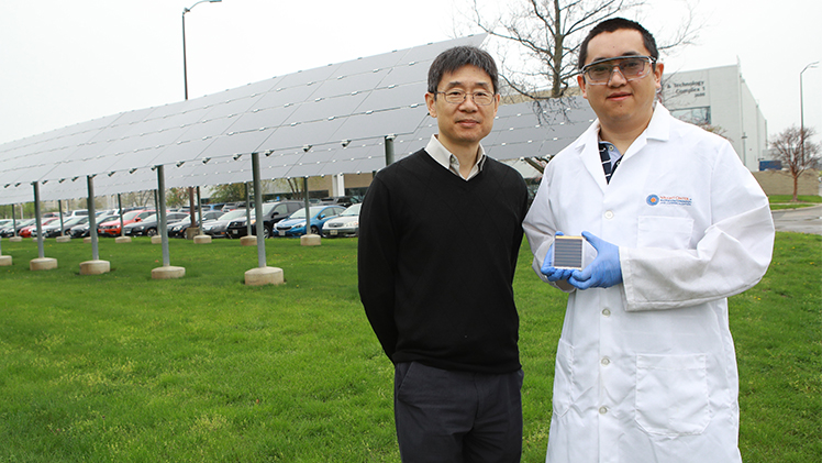 Dr. Yanfa Yan, a Distinguished University Professor of physics, and Dr. Zhaoning Song, a research assistant professor in the UToledo Department of Physics and Astronomy, outside with Song holding a small solar cell.