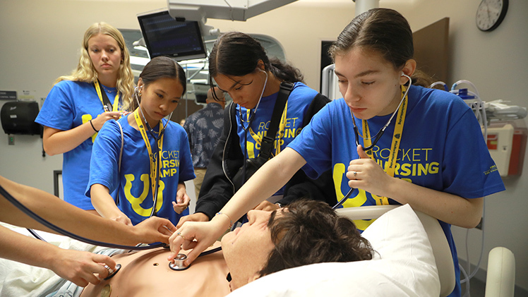 A high school student listens to the heartbeat from a medical dummy during a session on cardiac arrest as part of UToledo's College of Nursing Rocket Nursing Camp on July 26..
