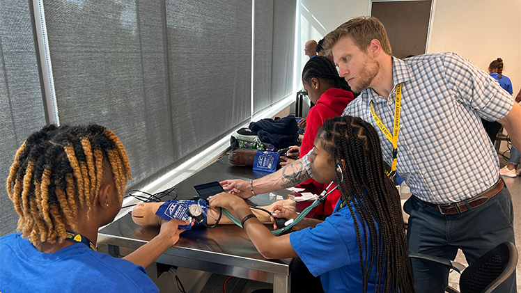 Dr. Aaron Lengel, a licensed pharmacist and assistant professor in the College of Pharmacy and Pharmaceutical Sciences, assists high school students during an instruction session at the UToledo Pharmacy and Science Career Camp.