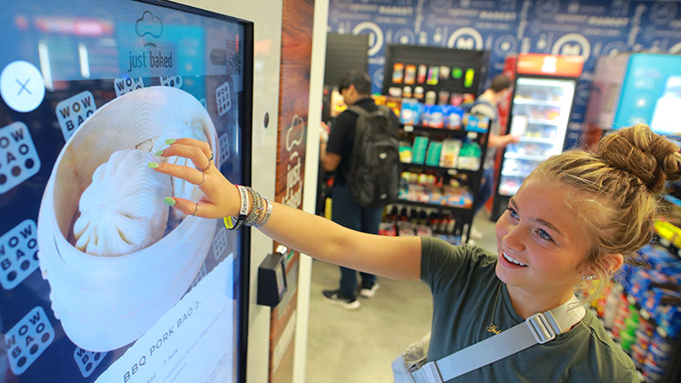 Joslyn Dolan, an exploratory studies sophomore who wants to become a physical therapist, explores the menu of Just Baked, one of two new vending kiosks in the expanded Market @ Student Union, relocated to the second floor of Thompson Student Union.