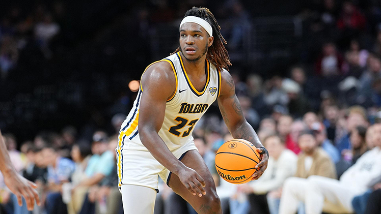 Photo of Tyler Cochran, a player from Toledo Men's Basketball team, dribbling a ball during a game.