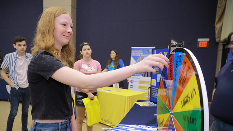Kendyl Roberts, a high school student from Spencerville, Ohio, spins the prize wheel at the Discovery Day event at Thompson Student Union Auditorium.