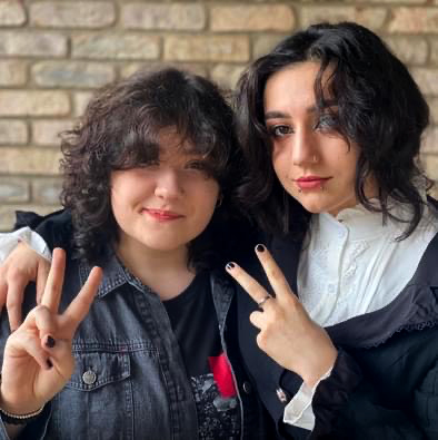 Both Nadia Jabri, right, with her younger sister, Hala Jabri. give peace signs in a photo of the two of them..