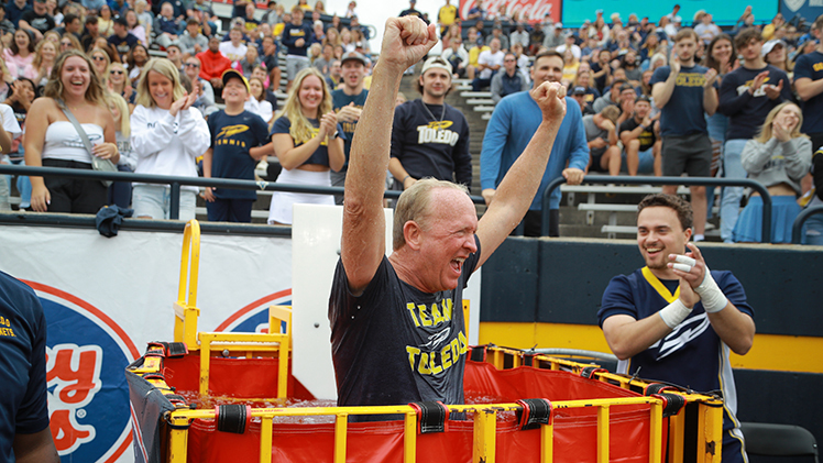 UToledo President Gregory Postel celebrates getting dunked following the Rockets’ first touchdown in Saturday’s 71-3 victory over Texas Southern at Glass Bowl Stadium. The sideline dunking booth is among several additions to Toledo home games, with dunk booth guests taking the plunge every time the Rockets score a touchdown.