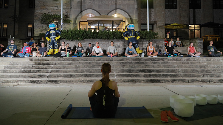 Students conduct yoga under the stars, one of several interactive activities during Light Up the Night. The event was hosted by the University Counseling Center.