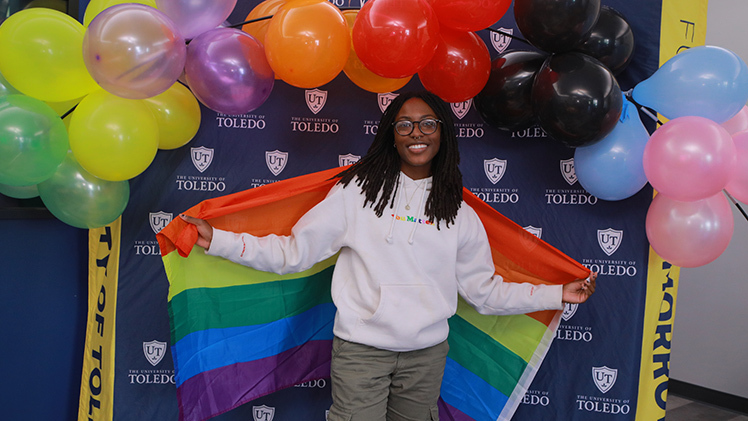 Danielle Robinson, a junior studying middle childhood education, poses with a rainbow flag Wednesday at the Office of Multicultural Student Success’ “Loving Your Queerness; Coming Out Day” photo shoot in Thompson Student Union.