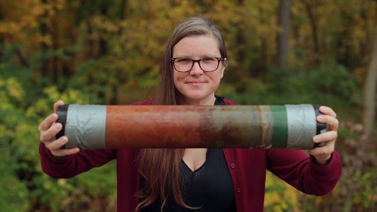 Feature photo of Dr. Trisha Spanbauer, an assistant professor in the Department of Environmental Sciences, holds a cores taken from Lake Erie.