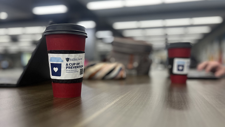 Photo of a table with two large coffee cups with 'Cup of Prevention' wrappers on them.
