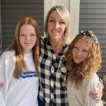 UToledo Law graduate Kayte Geist' poses with her two young daughters outside her home.