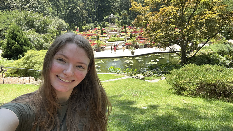Selfie of UToledo student Katie Blandford with a water garden behind her at the Sarah P. Duke Gardens at Duke University.