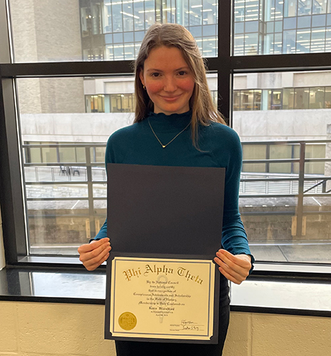 Katie Blandford, a double major in history and women and gender studies, poses with her certificate for the competitive Undergraduate Summer Research and Creative Activity Program (USR-CAP) grant earlier this year to fund research for her undergraduate honors thesis.