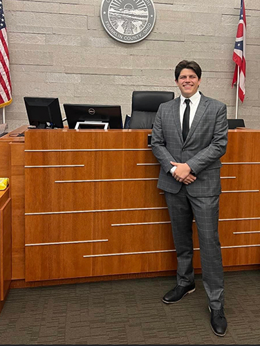 UToledo College of Law graduate Cameron Ervin poses in a courtroom.