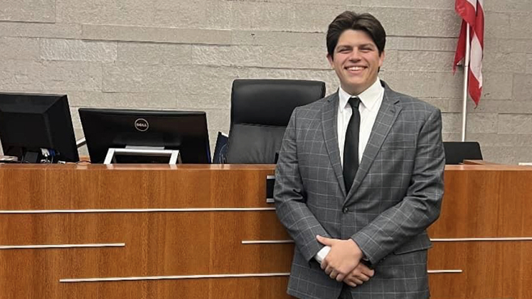 Law student Cameron Ervin poses in a courtroom.