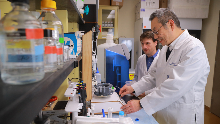 Dr. Shi-He Liu, an assistant professor of cell and cancer biology, works in his research lab with a research partner.