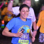 Angelina Mata, a senior in the College of Pharmacy and Pharmaceutical Sciences, crosses tje finish line of the Dopey Challenge at Disney World in Orlando, Florida, while wearing a Rocket Kids T-shirt.