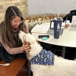 A UToledo law student greets Fiona, the law dog and unofficial College of Law mascot.