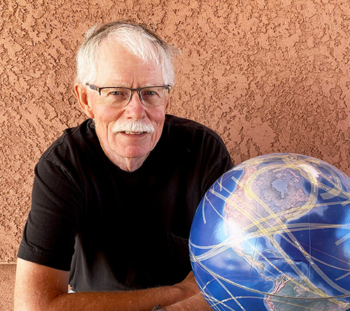 Photo of Fred Espenak and a globe.