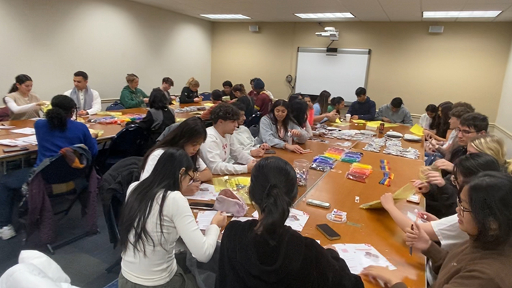 Large group of student volunteers at the UToledo chapter of Project Sunshine event to assemble activity kits for pediatric patients nationwide.