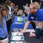 Annie Sayoto, a first-year doctor of physical therapy student, talks with Chris Sullivan, a physical therapist with NovaCare Rehabilitation, during the 2024 job fair for occupational therapy, physical therapy and speech-language pathology students Wednesday morning in Thompson Student Union Auditorium.