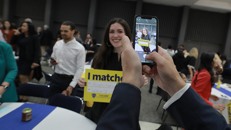 Photo of a UToledo student posing for a photo during Match Day at Stranhan Theatre for the college of medicine and life.