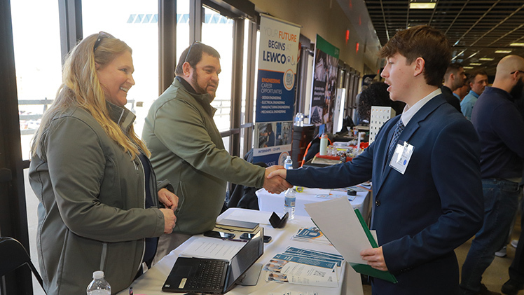 Tyler Kocsis, a mechanical engineering senior, shakes hands after his interview with automotive supplier Auria at the College of Engineering’s Spring Career Expo in Savage Arena.