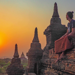 Photo of a man sitting on a wall during a sunset in Bagan.