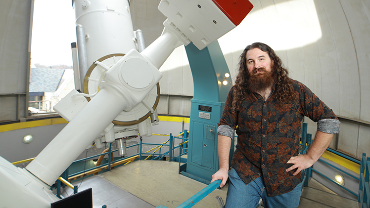 Sam Beiler, a doctoral student in physics, poses for a photo in UToledo's Ritter Planetarium.