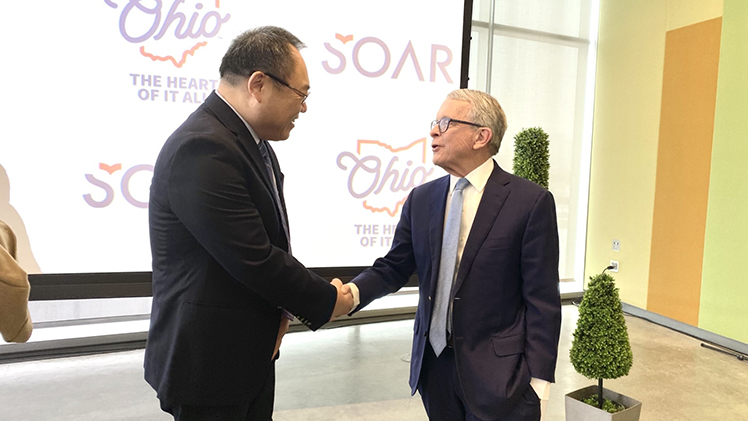 Dr. Xin Wang, a professor of psychiatry and neuroscience at UToledo, shakes hands with Ohio Gov. Mike DeWine.