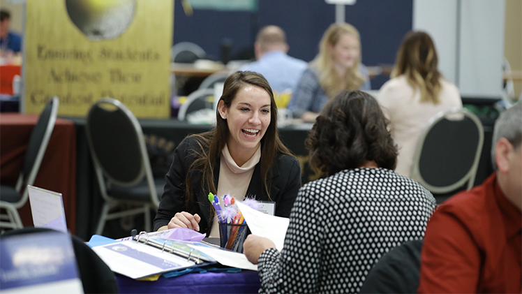 Photo of two women talking during a job fair.